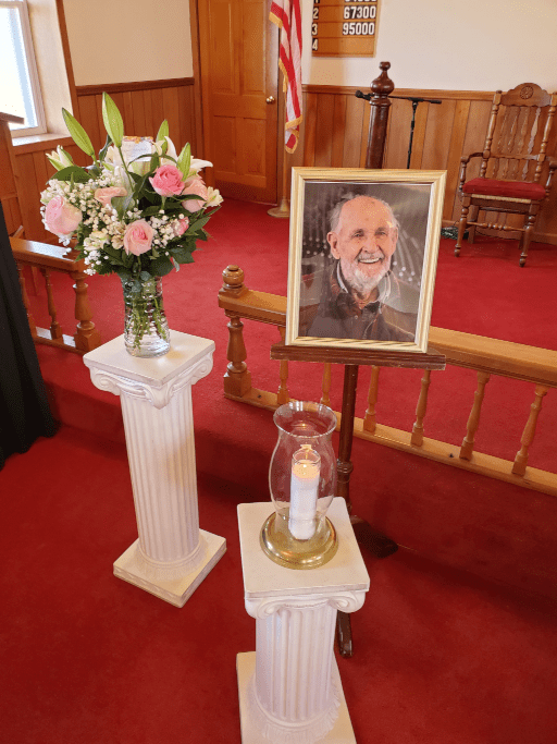 Flowers, photo, and candle at the funeral service.